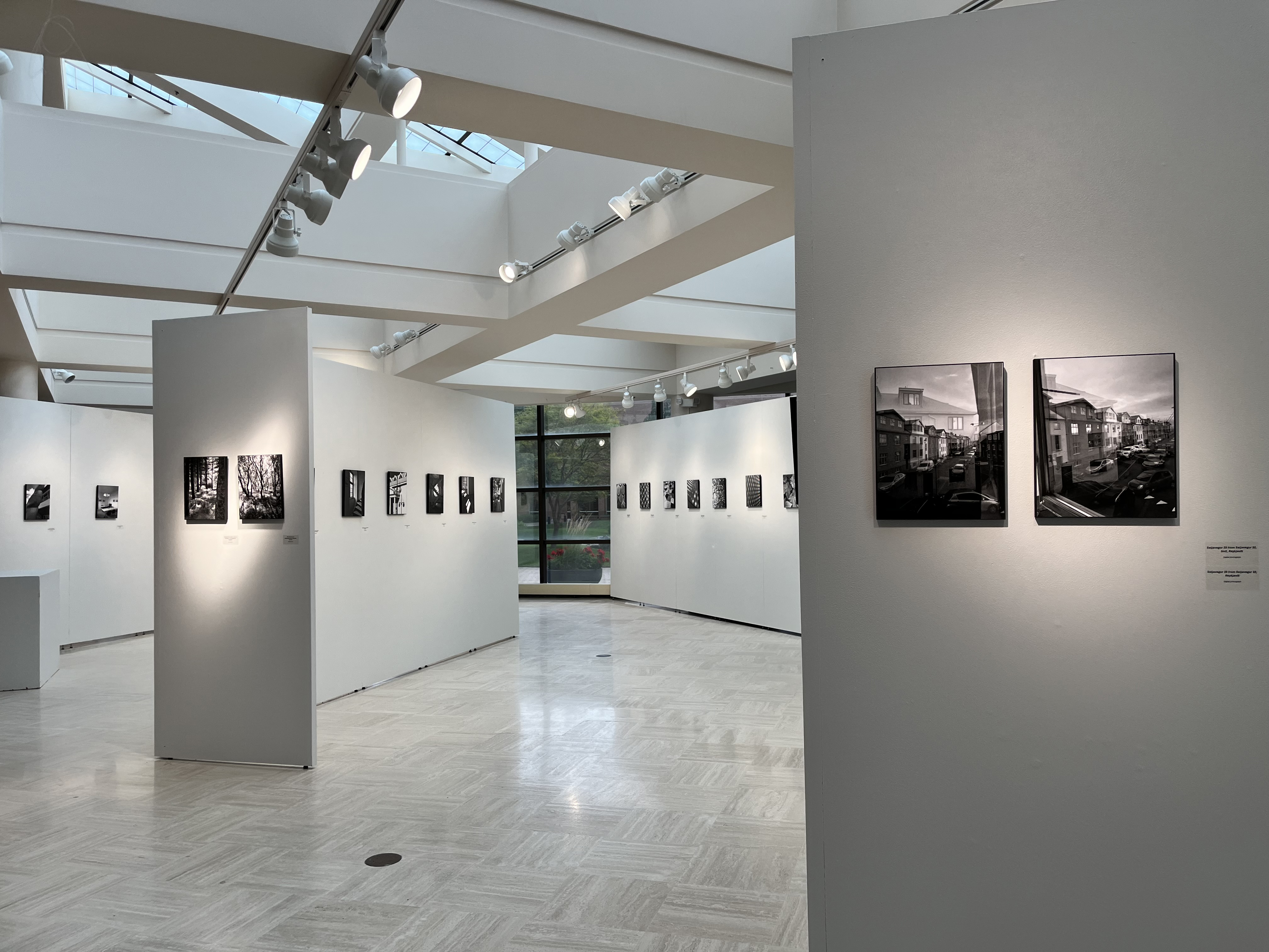 Exhibition of black and white photo graphs seen from the north end of the gallery looking south to the outside